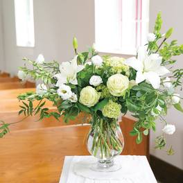 White lilies and roses in a clear glass vase
