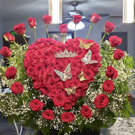 Heart-shaped red rose arrangement with butterfly decorations