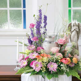Pastel floral centerpiece with candles and an angel statue