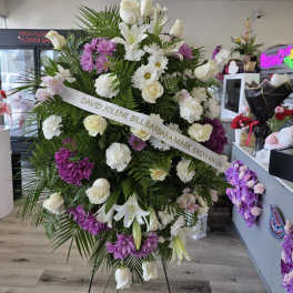 Large standing floral spray with white roses, lilies, and purple daisies