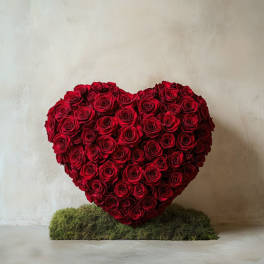 Heart-shaped arrangement of red roses on a moss base