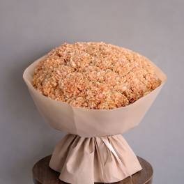 Peach hydrangea bouquet wrapped in beige paper
