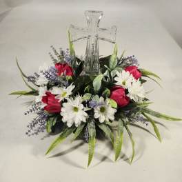 Floral arrangement with a clear glass cross centerpiece