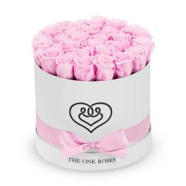 Pink roses arranged in a round white hat box with a pink ribbon