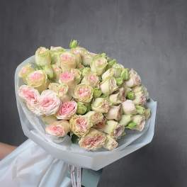 Large bouquet of pale cream and blush pink roses wrapped in white paper