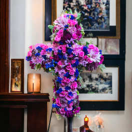 Cross-shaped floral arrangement in pink, purple, and blue flowers