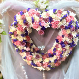 Heart-shaped floral wreath with pink, white, and purple flowers