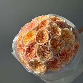 Bouquet of peach and cream roses wrapped in white paper