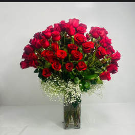 Bouquet of red roses in a clear glass vase with white baby's breath