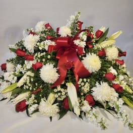 Large red, white, and yellow floral spray with a red ribbon bow