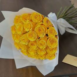 Bouquet of yellow roses wrapped in white paper