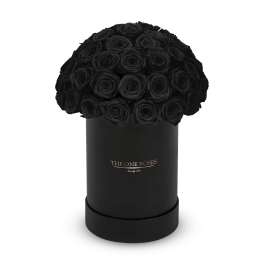 Black roses arranged in a round black box