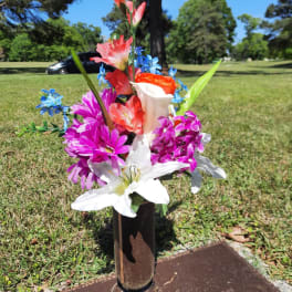 Colorful flower arrangement placed on a grave marker outdoors