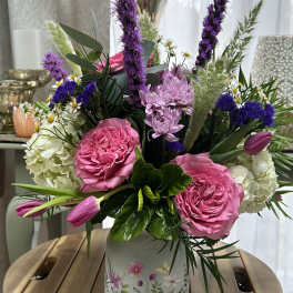 Pink and purple mixed flower arrangement in a floral ceramic vase