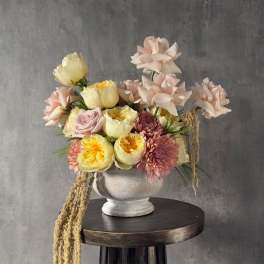 Pastel floral arrangement in a white urn vase