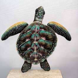 Decorative turtle sculpture with iridescent shell on a stone base