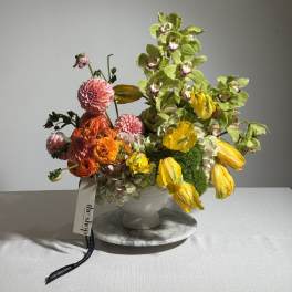 Colorful floral arrangement in a white vase with yellow and pink blooms