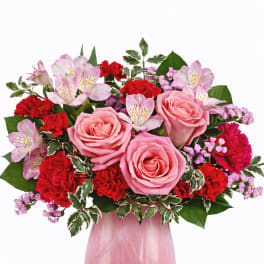 Pink roses and red carnations in a glass vase