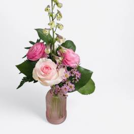 Pink and white roses in a pink glass vase