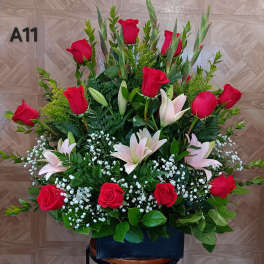 Large arrangement of red roses and pale lilies with baby's breath