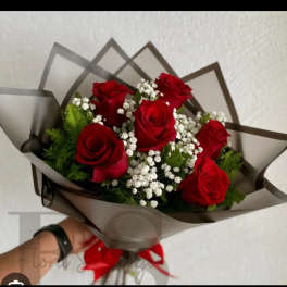 Bouquet of red roses with white baby's breath in dark wrap