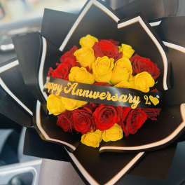 Bouquet of red and yellow roses wrapped in black paper