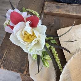 Boutonniere with white and red flowers on beige fabric
