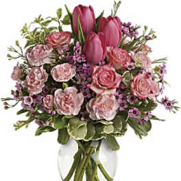 Pink tulips and roses arranged in a clear glass vase