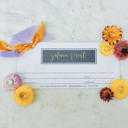 Gift card surrounded by colorful dried flowers and ribbon