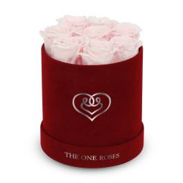 Pink roses in a red velvet hat box with a heart emblem