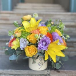 Bright mixed bouquet in a ceramic vase with yellow lilies and roses