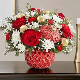 Red roses and white daisies in a red patterned vase with gold ornaments