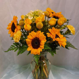 Sunflowers and yellow roses in a glass vase