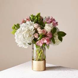 Pink and white flower arrangement in a clear glass vase