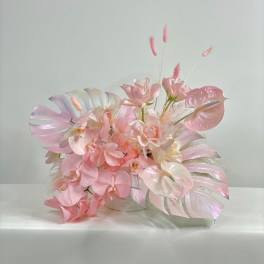 Pink and white orchid arrangement in a low container