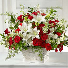 Red roses and white lilies in a white basket arrangement