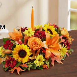 Autumn floral centerpiece with a tall orange candle