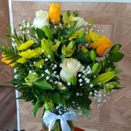 Bouquet of yellow and white roses with lilies in a glass vase