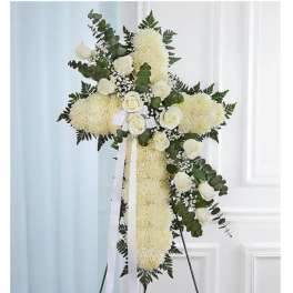 White floral standing cross on an easel with ribbon