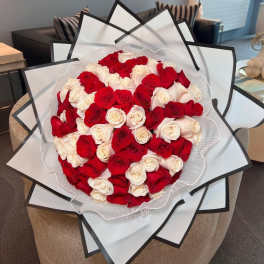Large bouquet of red and white roses wrapped in layered white paper