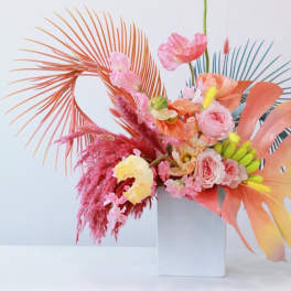 Colorful floral arrangement in a white vase with pink and peach blooms