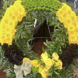 Yellow floral wreath with roses and chrysanthemums on a stand