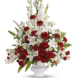 Red roses and white gladiolus in a white urn vase