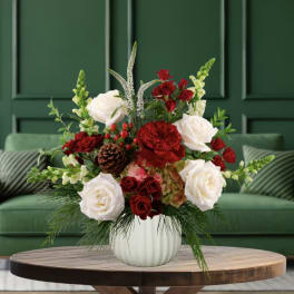 Red and white roses arranged in a white vase