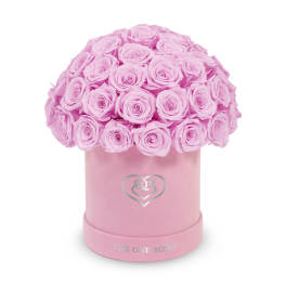 Pink roses arranged in a round pink hat box