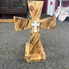 Wooden cross-shaped decor with a small white cross on the front