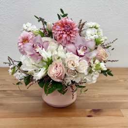 Pink and white floral arrangement in a blush vase