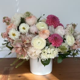 Mixed pastel flower arrangement in a white vase