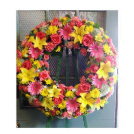 Circular wreath of pink, yellow, and red flowers on a stand