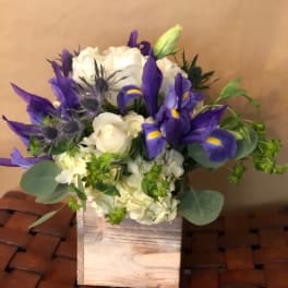 Purple irises and white roses in a wooden box